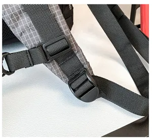 Dettaglio della cinghia dello zaino con fibbia regolabile e tessuto grigio resistente.