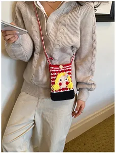 Knit-Handytasche Detail mit süßem Cartoon-Mädchen und rot-weißem Karomuster.
