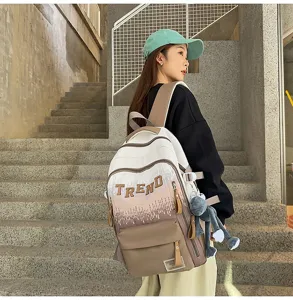 Detailed view of the stylish gradient backpack featuring trendy letter embroidery and a cute plush doll.
