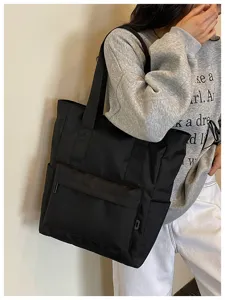 Borsa shopper nera minimalista di grande capacita, borsa a spalla con dettagli pratici utili.