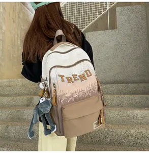 Gradient large capacity school backpack with trendy letter print and cute doll pendant detail.