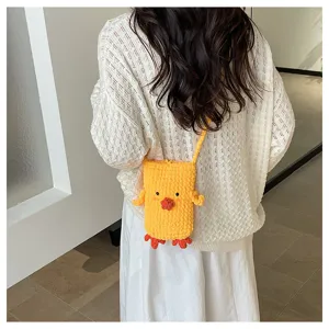 Detail shot of the cute handmade knitted yellow duck crossbody phone bag, showing texture.