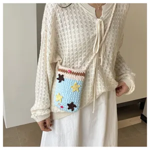 Handmade knitted phone bag detail, cute star decoration, cross-body strap design.