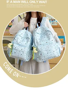 Detailed view of light blue star print backpack with cute moon pendant for daily school use.