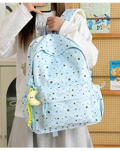 Light blue star print school backpack detail view, cute casual daypack with moon pendant