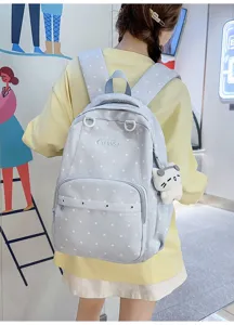 Vue détaillée du sac à dos bleu clair à pois avec poche avant et joli pendentif chat.