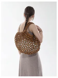 Sac porté épaule en perles de bois détail, cabas de plage ajouré, accessoire de vacances chic.