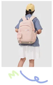 Vue détaillée du sac à dos rose pour étudiant avec un joli pendentif chat et des bretelles.