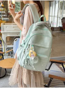 Mint green multi-compartment school backpack detail with star print and cute plush pendant.