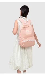 Detailansicht des rosa Pünktchen-Schulrucksacks mit süßer weißer Borte und Fronttasche.