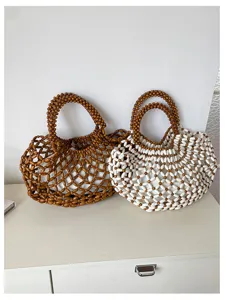 Vue détaillée de sacs fourre-tout perlés faits à la main avec des motifs ajourés complexes.