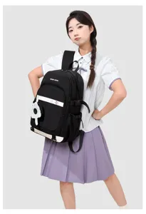 Détail du sac à dos scolaire noir avec joli pendentif chat et poche avant pratique.