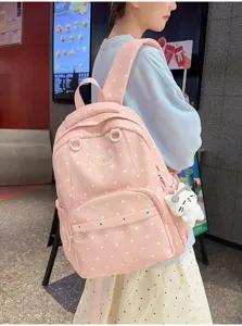 Détail du sac à dos rose à pois, cartable élégant pour étudiant avec joli pendentif mignon.