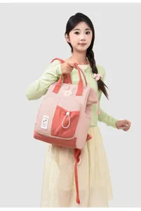 Detailed view of the stylish color-blocked casual backpack with cute bear patch and handy pockets.