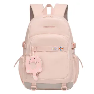 Vue rapprochée du joli sac à dos d'étudiant rose avec pendentif chat joueur et belles coutures.