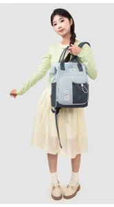 Detailed view of the color-blocked mommy backpack with cute bear badge and spacious design.