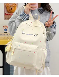 Nahaufnahme eines süßen japanischen Beigen Polka-Dot-Rucksacks mit Engelsflügel-Stickerei.