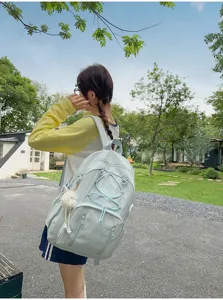 Casual light blue canvas school backpack with drawstring detail and cute plush pendant charm.