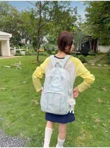 Outdoor detail view of light blue student backpack with drawstring and functional pockets.