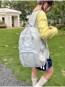 Detailed view of light blue Japanese style backpack featuring drawstring and plush pendant.
