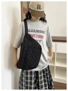 Detailansicht der schwarzen karierten Nylontasche, getragen in einem lässigen Raum.