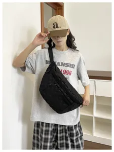 Detailansicht der schwarzen Nylontasche mit Struktur, getragen vom Model für den urbanen Look.