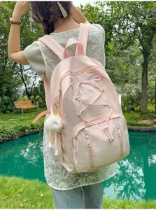Pink Japanese style student backpack with drawstring and cute fluffy pendant detail.