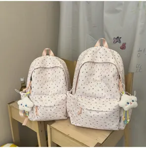 Rosa blumiger Schulrucksack Detailansicht mit niedlichem Sternanhänger und grossen Taschen.