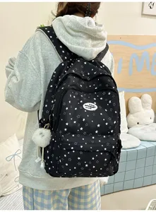 Sac à dos scolaire noir à motif d'étoiles, multiples compartiments et pendentif en peluche.