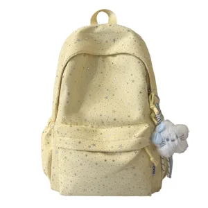 Detailansicht des hellgelben Sternenmuster Schulrucksacks mit flauschigem Katzenanhänger.