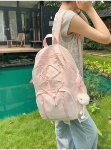 Pink large capacity student backpack with cute plush pendant and stylish drawstring details.