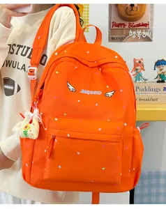 Nahaufnahme des niedlichen orangefarbenen Polka-Dot-Rucksacks mit Stickerei im Detail.