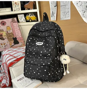Vue détaillée d'un joli sac à dos d'école à motif d'étoiles avec compartiments et pendentif.