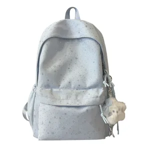 Detailansicht des hellblauen Rucksacks mit Sternenmuster und süßem Plüschanhänger für Schüler.