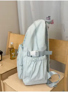 Casual light blue backpack with drawstring pockets and side buckle straps for daily student use.