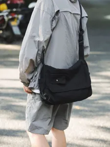 Schwarze Canvas Umhängetasche, crossbody von Model im Freien, lässige Pendler Schultertasche.