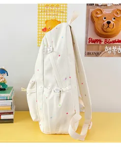 Seitenansicht eines niedlichen japanischen Polka-Dot-Rucksacks in Beigefarben mit bunten Punkten.