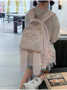 Vue détaillée du joli sac à dos rose à rayures et étoiles avec oreilles de lapin en scène.