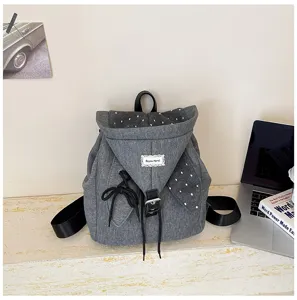 Grauer Segeltuch-Rucksack mit Kapuzenklappe, niedlichen Pünktchen-Details und praktischem Kordelzug.