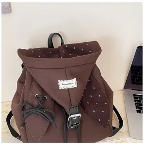 Brauner süßer Studentenrucksack Detail, mit süßer Schleife, Spitzenetikett und Klappe.