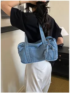 Vintage washed denim shoulder bag for women, casual commuter tote with mini coin pouch charm.