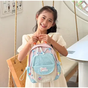 Detail shot of cute colorblock kids backpack showing playful design and cozy indoor setting.