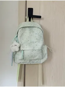 Detailansicht des mintgrünen Schülerrucksacks mit Sternenmuster, Vordertasche und Wolkenanhänger.