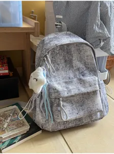 Grauer Rucksack mit Sternenmuster im Detail, mit Fronttasche und flauschigem Wolkenanhänger.