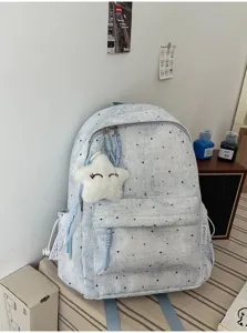 Detailansicht des niedlichen blauen Rucksacks mit Sternenmuster und Plüschstern-Anhänger.