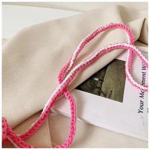 Detailansicht des rosa-weißen Strick-Umhängetaschenriemens für Handys, weich & stilvoll.