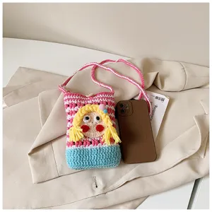 Nahaufnahme der süßen Häkel-Handy-Tasche mit Cartoon-Mädchengesicht und bunten Trägern.