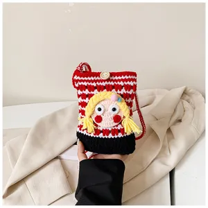 Detailansicht der süßen Häkel-Handytasche mit 3D Cartoon Mädchen Gesicht und gelben Zöpfen.