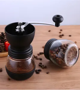 Handmatige glazen koffiemolen met zwengel en opbergpot voor verse koffiebonen.