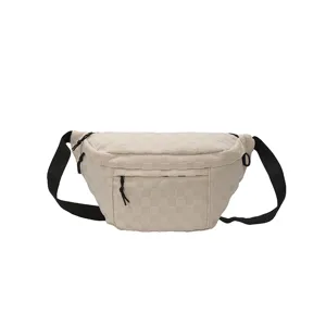 Detailansicht der lässigen, cremeweißen Brusttasche mit schwarzem Gurt und Reißverschluss.